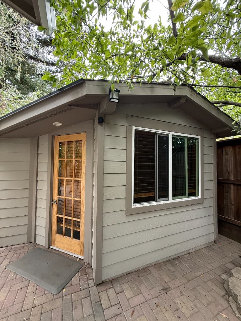 Custom sauna — exterior with wood door and sliding window