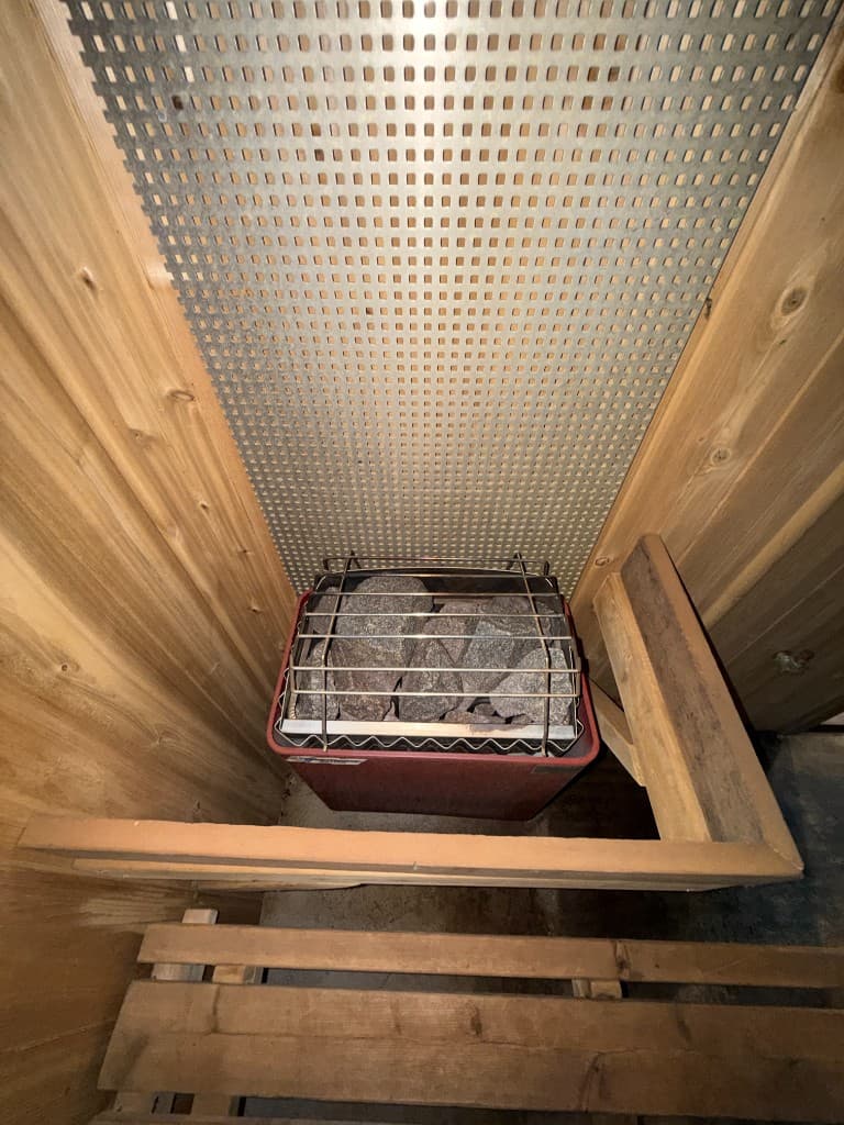 Custom sauna — heater with stone surround and heat guard