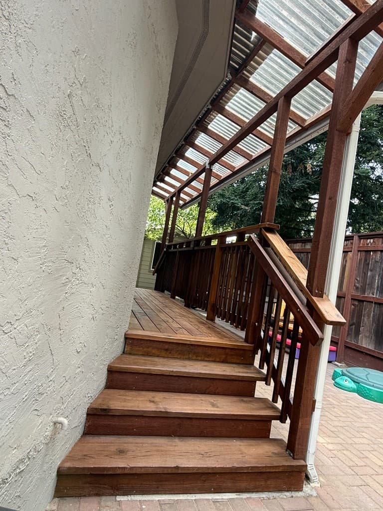 Deck construction — walkway with clear roof and wood railing